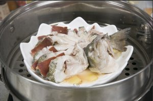 將鱸魚成花狀擺好，將火腿切片放入各縫隙中，放入鍋中隔水蒸12分鐘拿出，撒上蔥花即可。