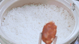 煮開后轉小火，當米飯出現小孔時，鋪上金字麻辣香腸。