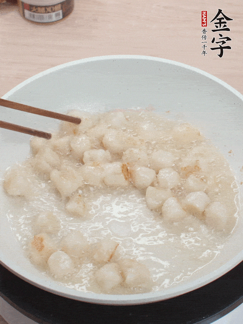 油溫4成熱，鮮貝蘸干淀粉下鍋煎，一面微黃后翻面。