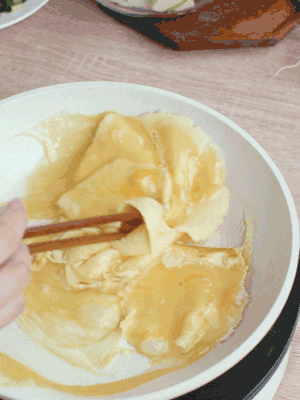 油6成熱時，下雞蛋液，邊緣凝固時翻拌成塊狀。