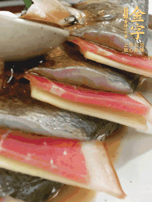 魚肚中塞蔥結(jié)、火腿片，魚身上碼放姜片、火腿片，倒入混合的料汁。